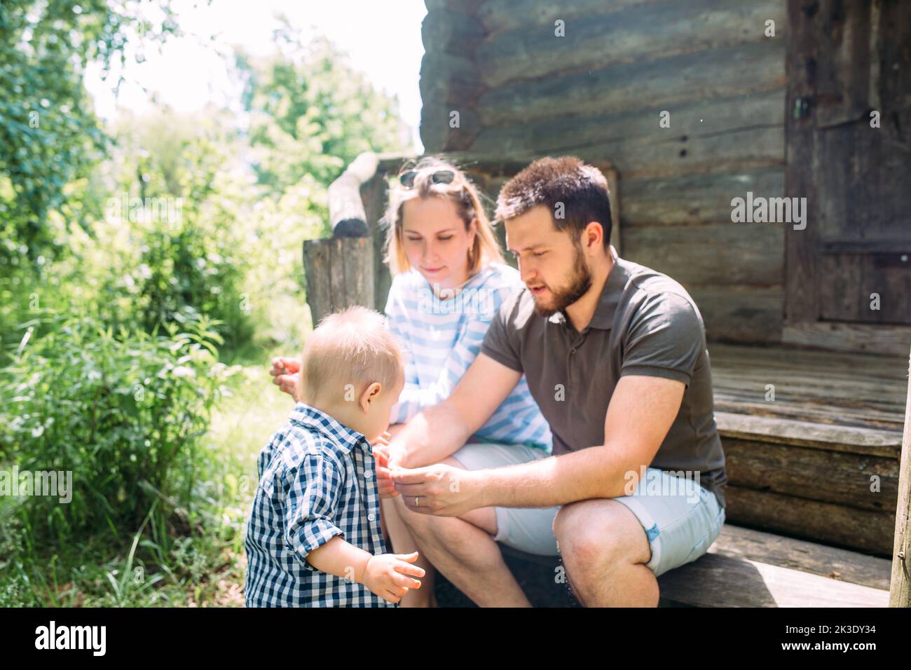 Mom, dad and little son spend time together in the summer outdoors ...