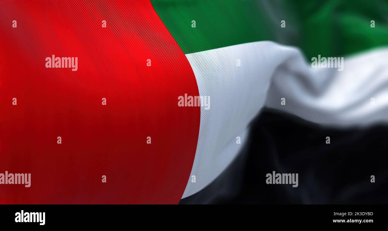 Close-up view of the United Arab Emirates national flag waving in the wind. The Emirates is a country in Western Asia. Fabric textured background. Sel Stock Photo
