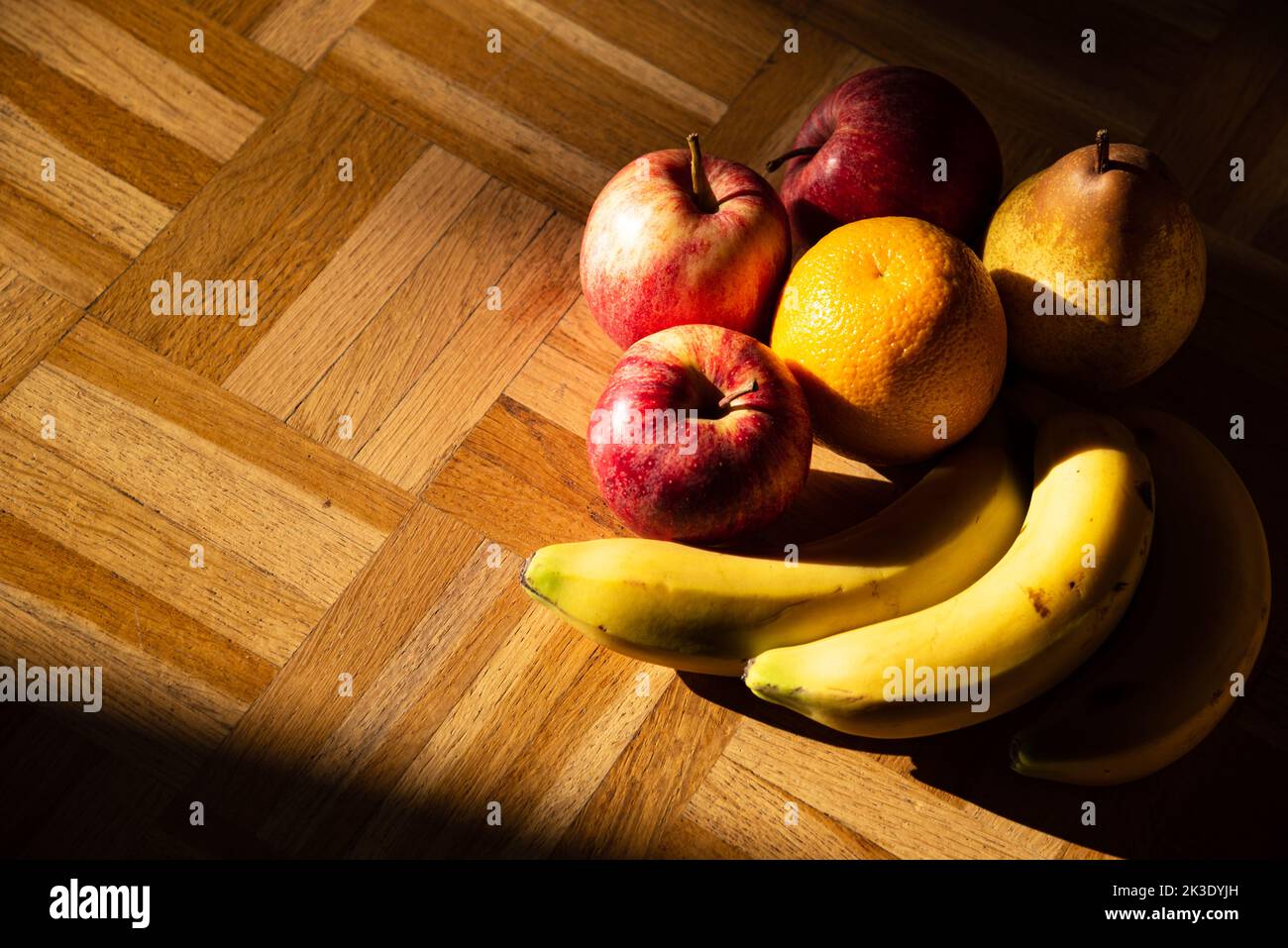 Still life with colorful organic apples, pear, orange banana ripe fruits on vintage wooden surface. Healthy eating background. Stock Photo