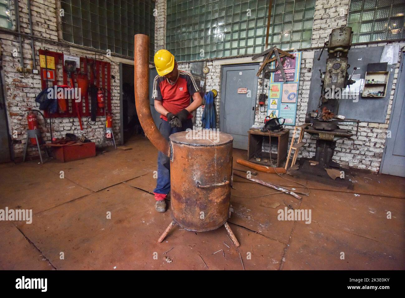A worker of the Lviv utility company makes a special metal stove for