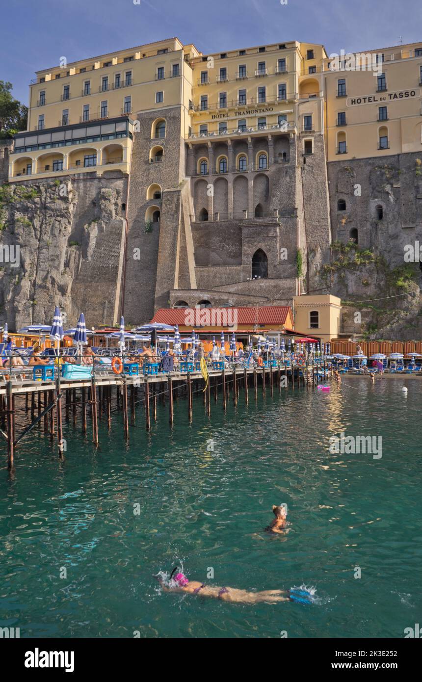 Tourists swimming and sunbathing at a private lido beach resort in the seaside resort of Sorrento near Naples,Italy Stock Photo