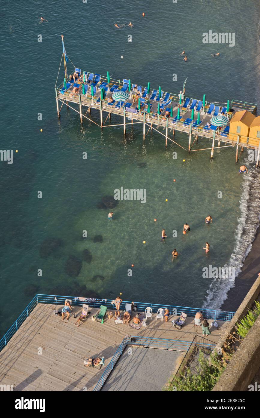 Tourists swimming and sunbathing at a private lido beach resort in the seaside resort of Sorrento near Naples,Italy Stock Photo