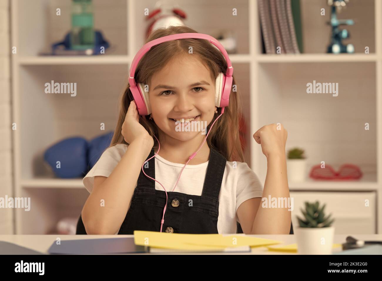 glad kid listen to music in headphones at school classroom Stock Photo