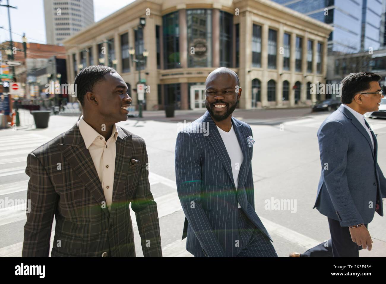 Stylish businessmen in suits walking on sunny city street hi-res stock ...