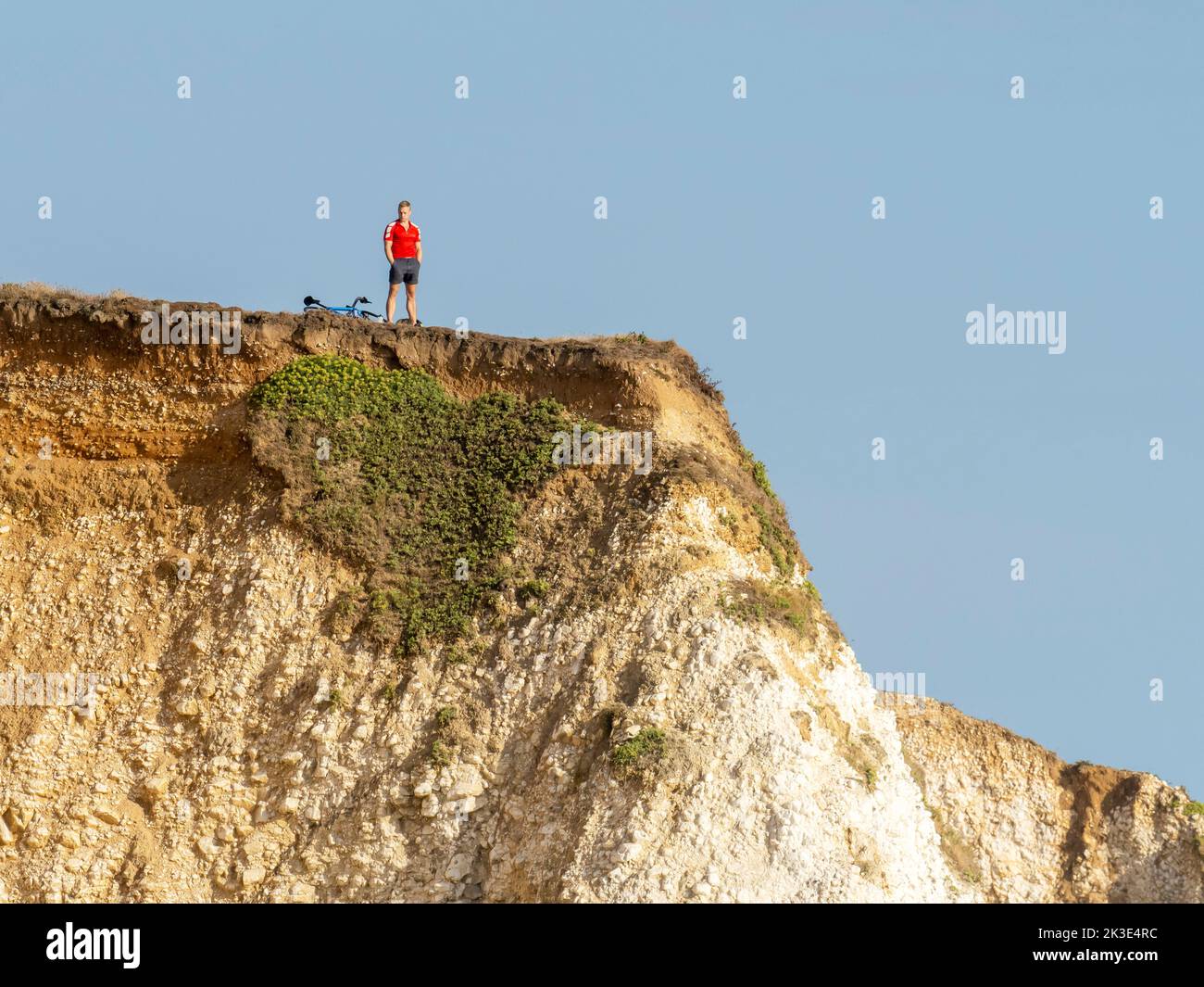 A man on the chalk sea cliffs in Freshwater on the Isle of White, UK. Stock Photo