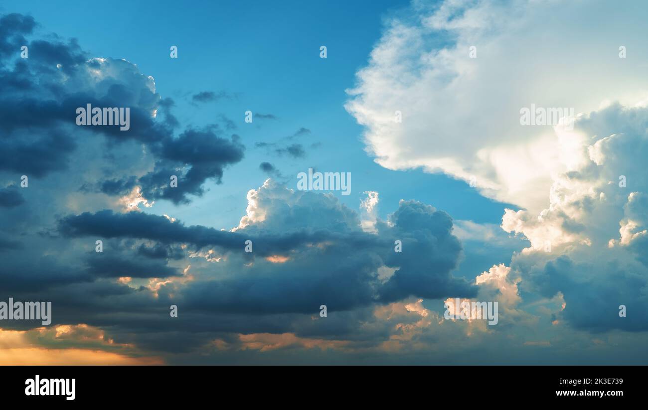 Cumulus fluffy sunset clouds sky background. Stock Photo