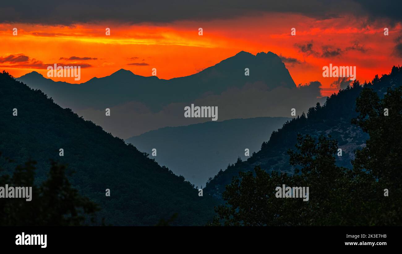 Fiery red sunset on the Gran Sasso mountain range, Il corno grande in silouette. Gran Sasso and Monti della Laga National Park, Abruzzo, Italy, Europe Stock Photo