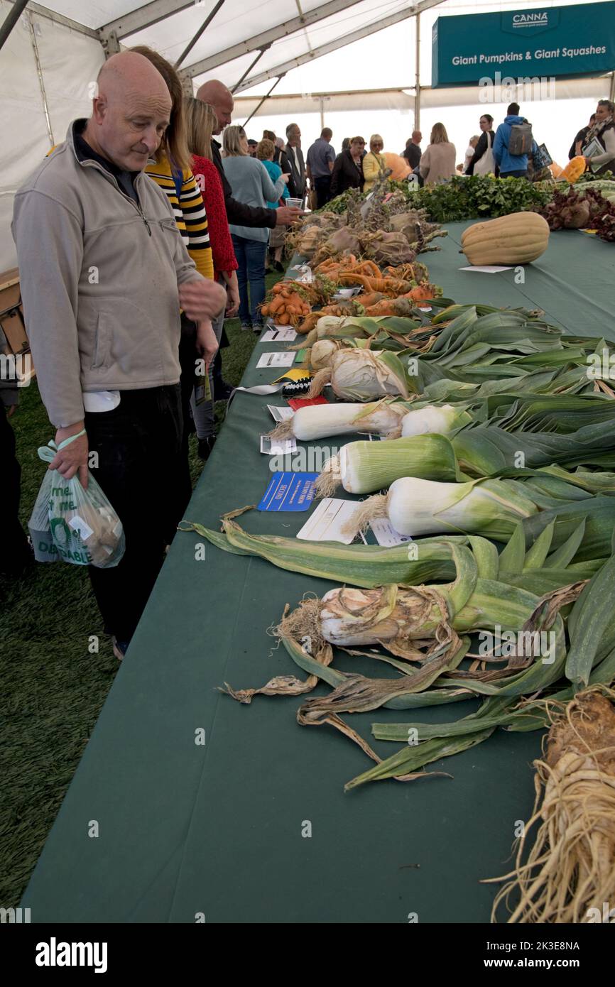 Visitors looking at giant leeks some of the giant vegetables at Three Counties Autumn Show  Great Malvern, UK Stock Photo