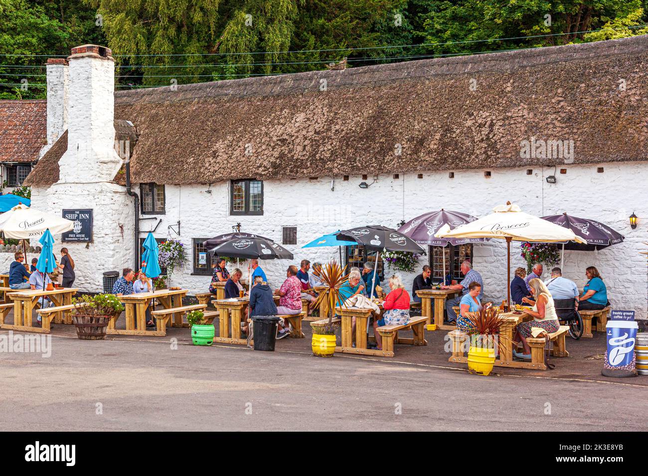 Al fresco eating and drinking at the Ship Inn on a summer evening by the harbour on the north coast of Exmoor at Porlock Weir, Somerset UK Stock Photo