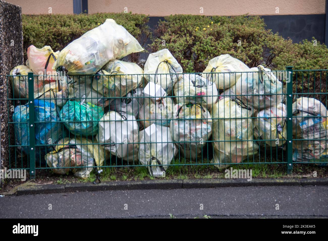 Many garbage bags lie in the front yard of the throwaway society Stock Photo