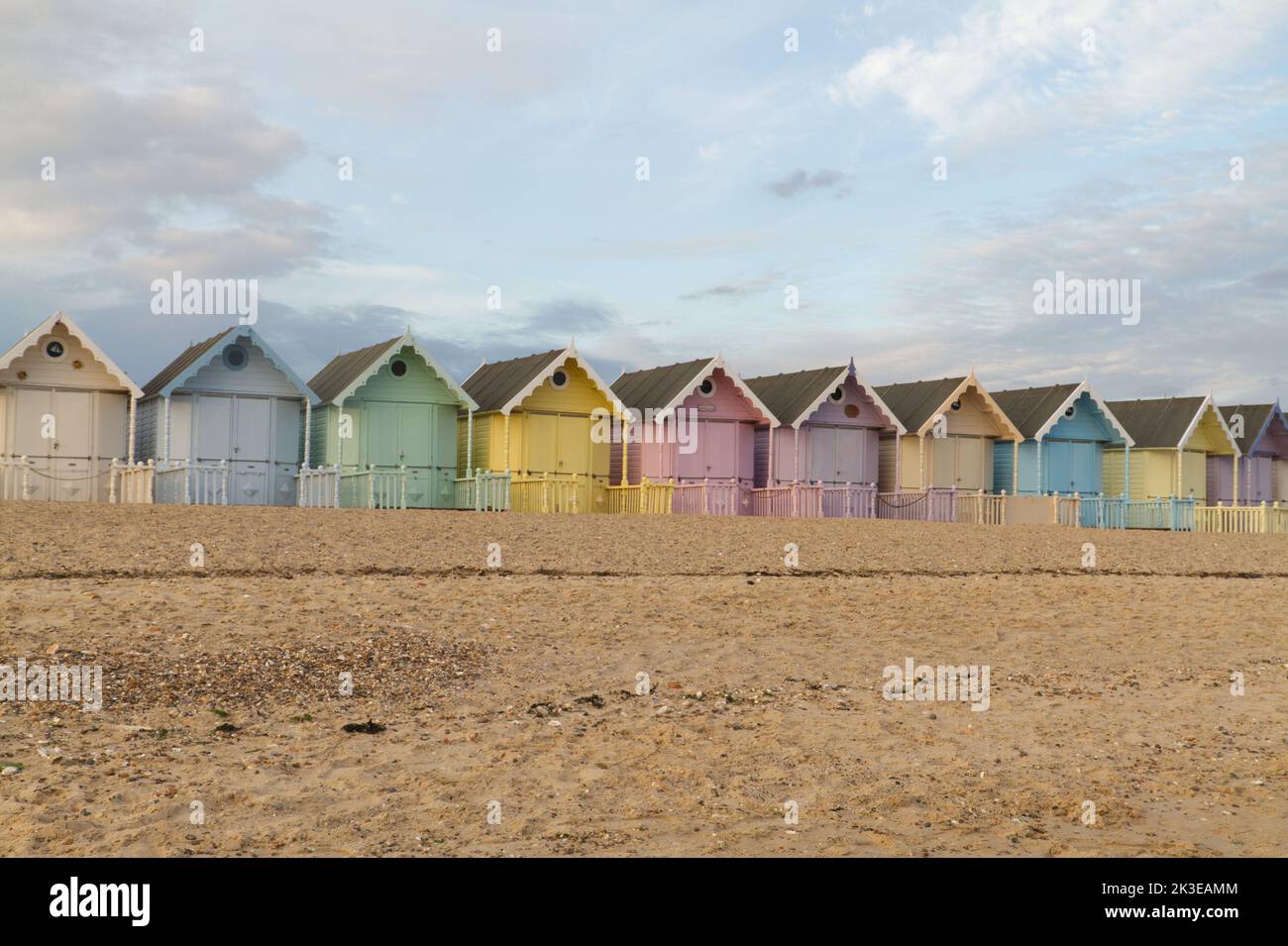 The beach huts at West Mersea on Mersea Island in Essex, a row of very pretty pastel coloured huts that are very popular with locals and visitors Stock Photo