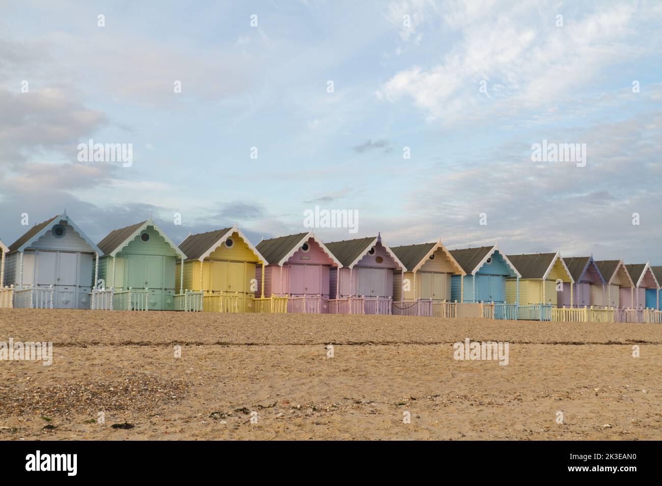 The beach huts at West Mersea on Mersea Island in Essex, a row of very pretty pastel coloured huts that are very popular with locals and visitors Stock Photo