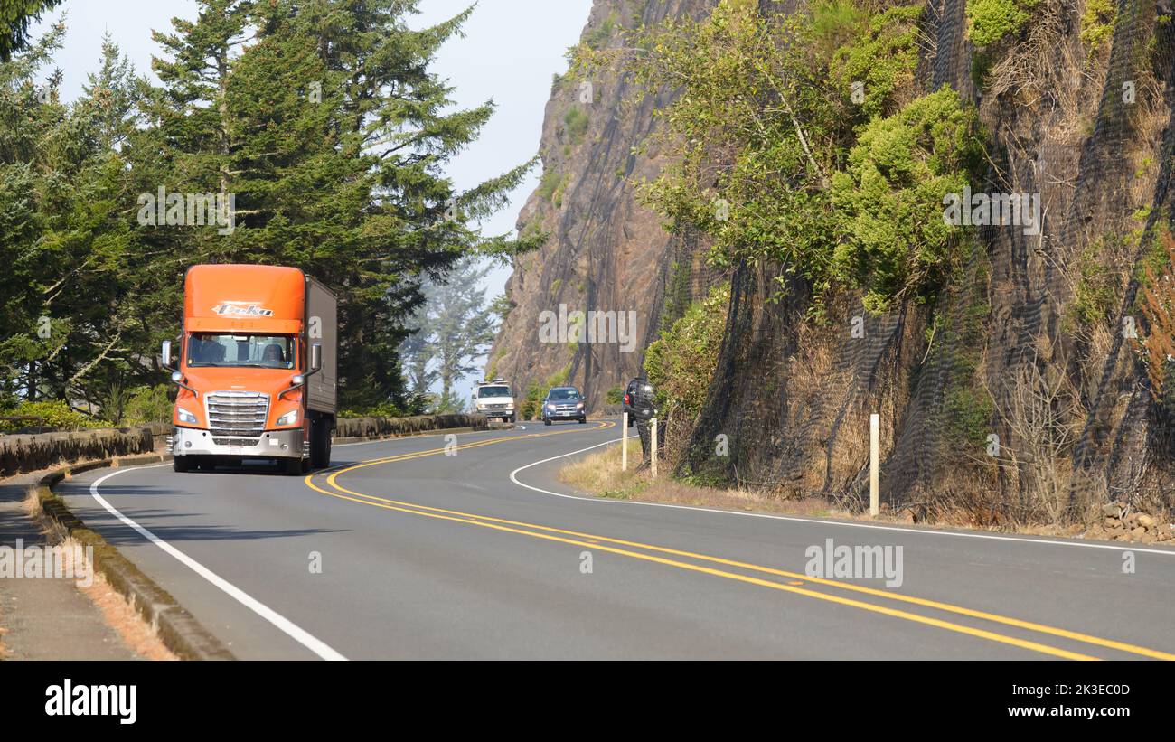 Nehalem, OR, USA - September 21, 2022; Orange truck travelling southbound through curves on Pacific Coast Highway in Oregon Stock Photo