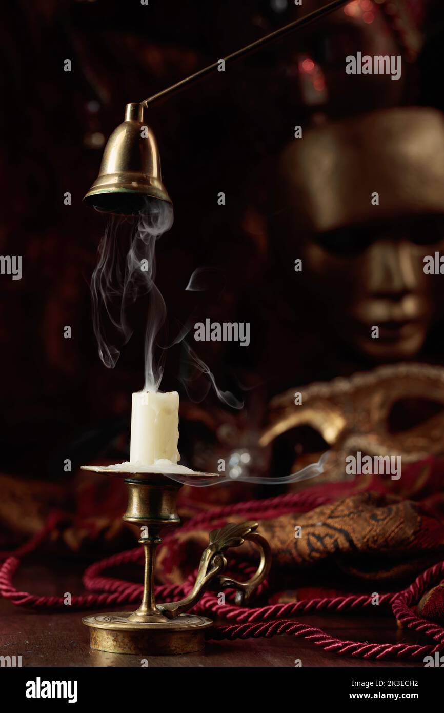 Still life with an extinguished candle in an old brass candlestick and