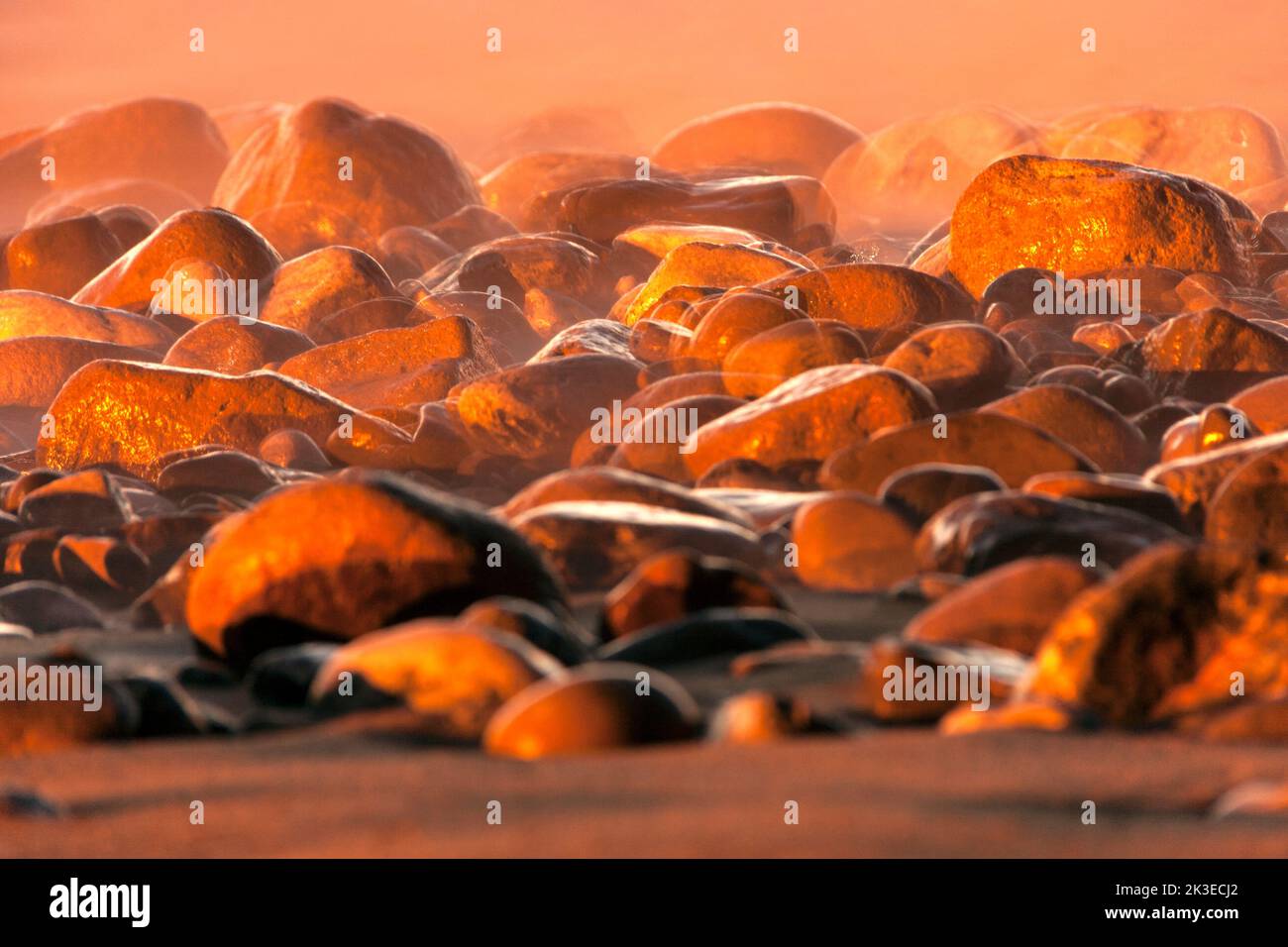 Close-up of many pebbles on the sand of the beach. Effect of movement. Wallpaper. Stock Photo