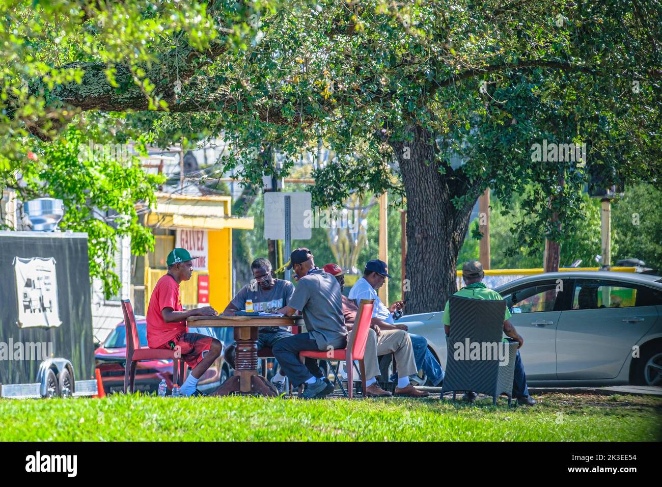 NEW ORLEANS, LA, USA - APRIL 20, 2020: Seniors playing dominoes on a Mid City median in the afternoon Stock Photo