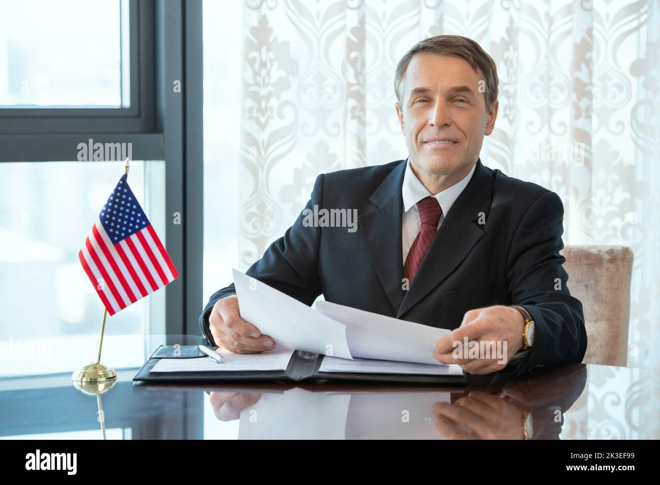 Photo realistic digital collage of successful American delegate or businessman in elegant suit looking through contract Stock Photo
