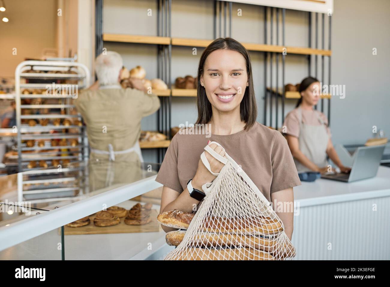 Ai generated face of happy young female baker making presentation of new assortment to mature colleague Stock Photo