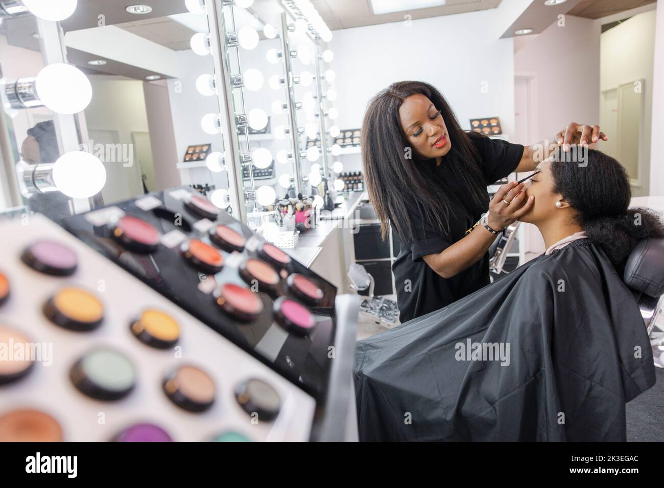 Makeup artist giving makeover to customer in beauty salon Stock Photo