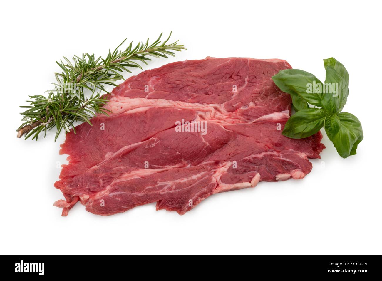 Raw beef steak with rosemary and basil leaves isolated on white Stock