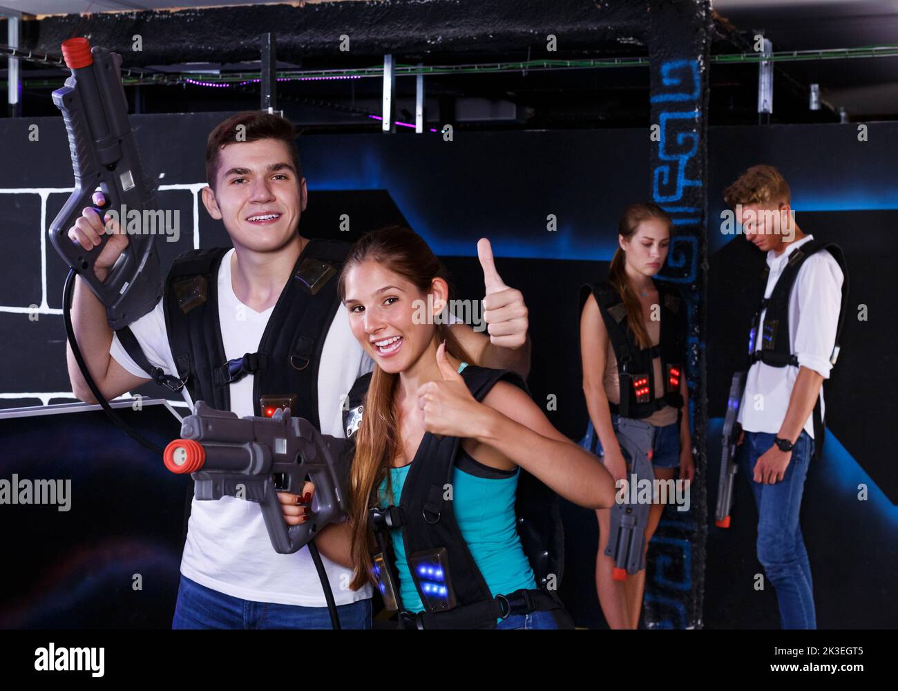 Guy and girl are happy with their victory in laser tag game Stock Photo