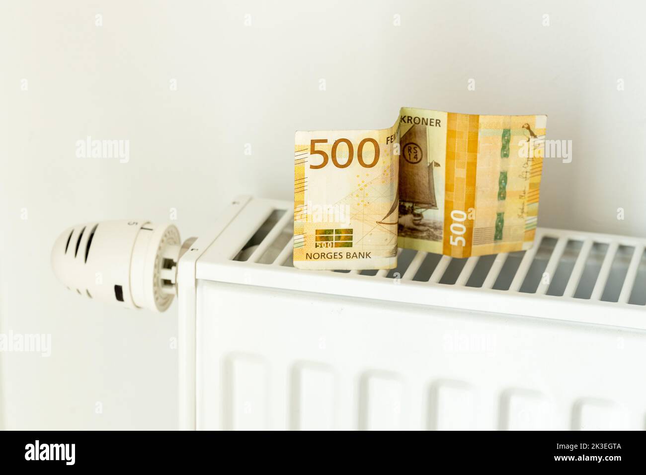 500 NOK Banknote Lying On The Radiator The Concept Of Rising Energy 500-nok-banknote-lying-on-the-radiator-the-concept-of-rising-energy