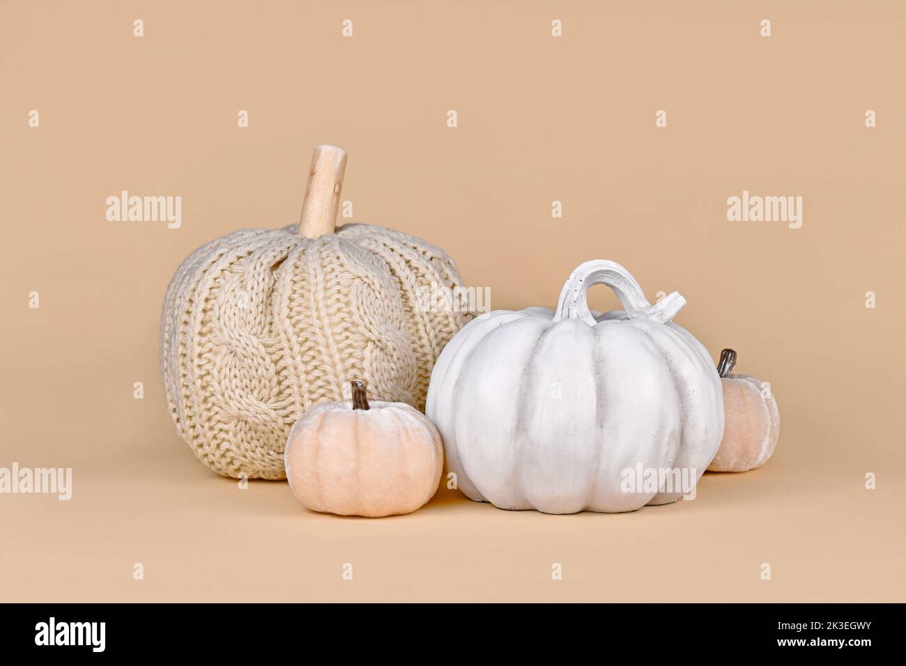 Autumn decoration with boho style knitted beige pumpkin and gray stone pumpkin Stock Photo