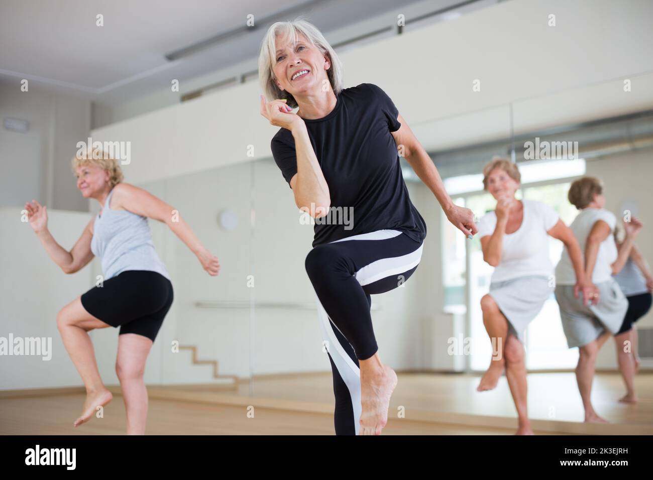 Portrait of mature energetic woman practicing active dancing at a group lesson Stock Photo