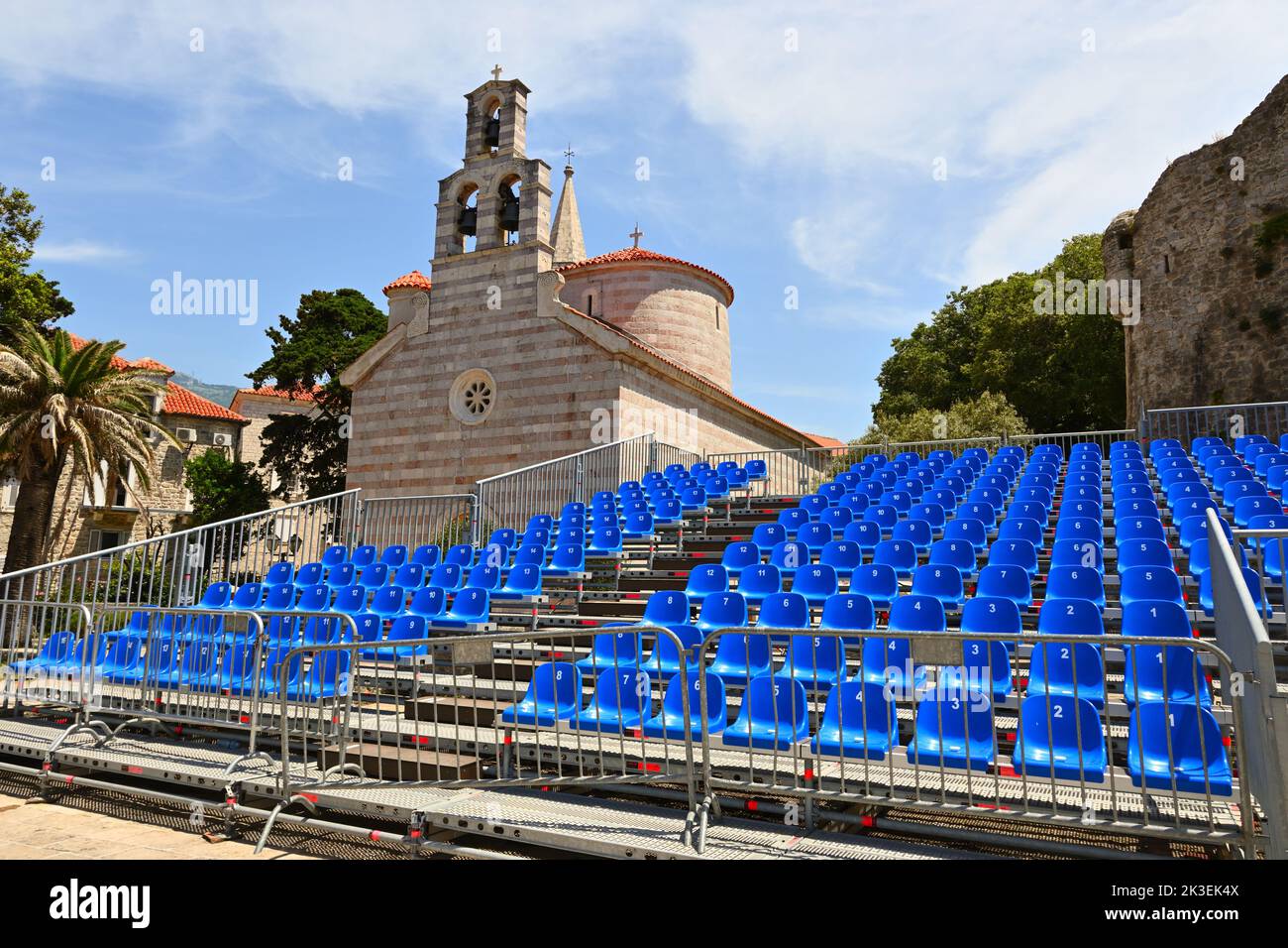 Blue chairs in the amphitheater. Church of the Holly Trinity in Budva Old Town. Montenegro Stock Photo