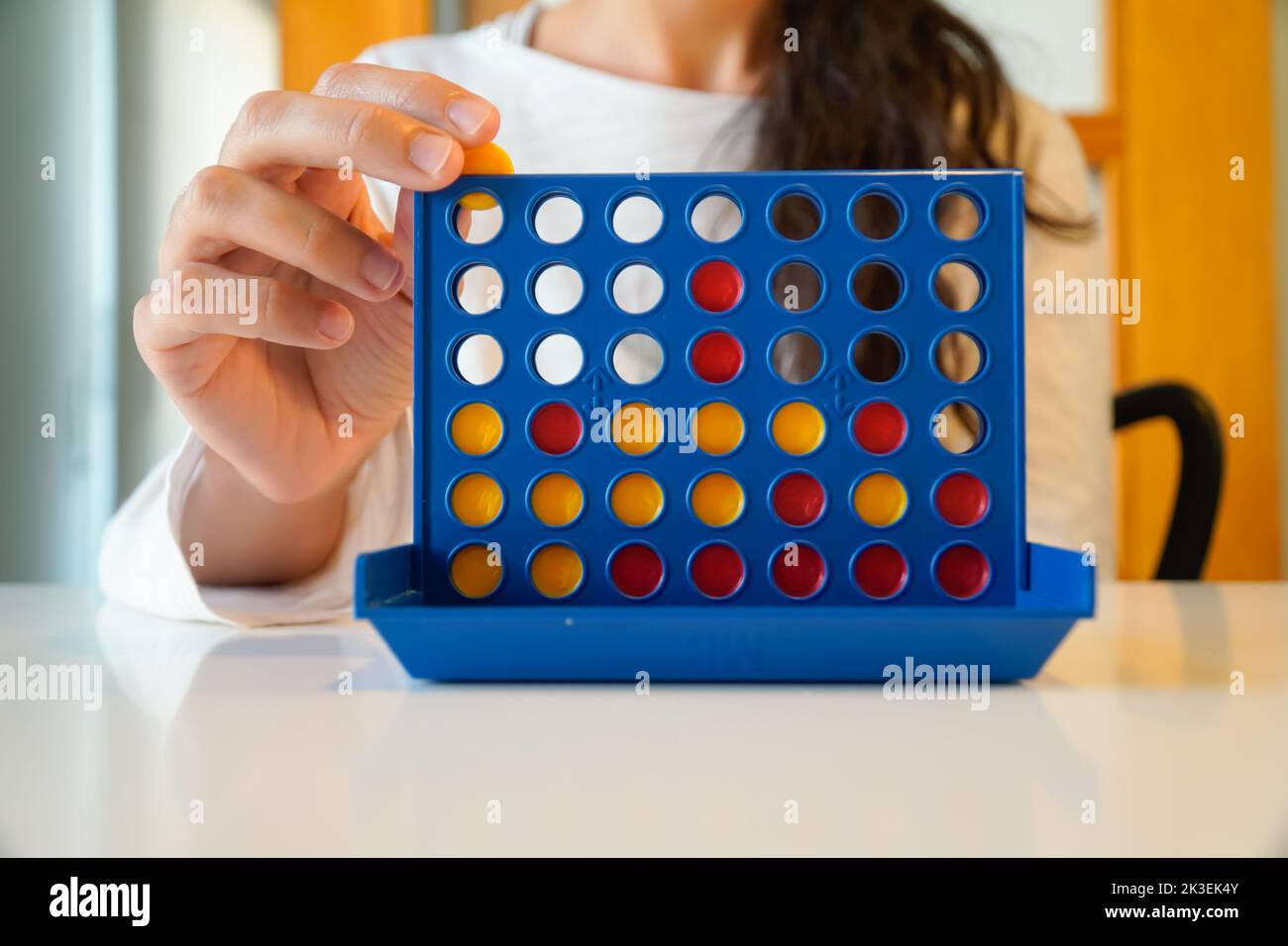 daughter plays educational board game. three in a row Stock Photo - Alamy