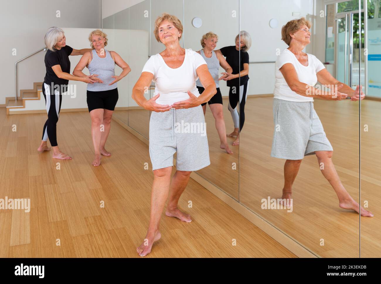 Senior lady learning classic dance moves during group class Stock Photo