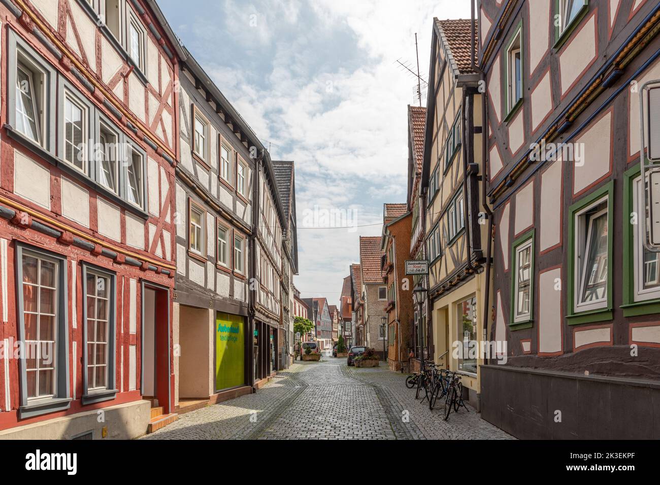 Alsfeld, Germany - June 25, 2021: small historic road covered with cobble stones and half timbered historic houses in Alsfeld, Germany. Stock Photo
