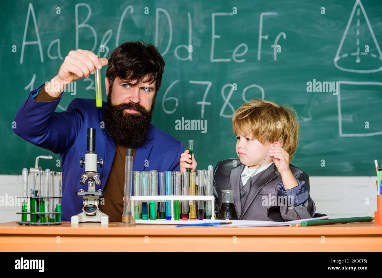 Teacher and pupil boy in chemical laboratory. Study chemistry and ...