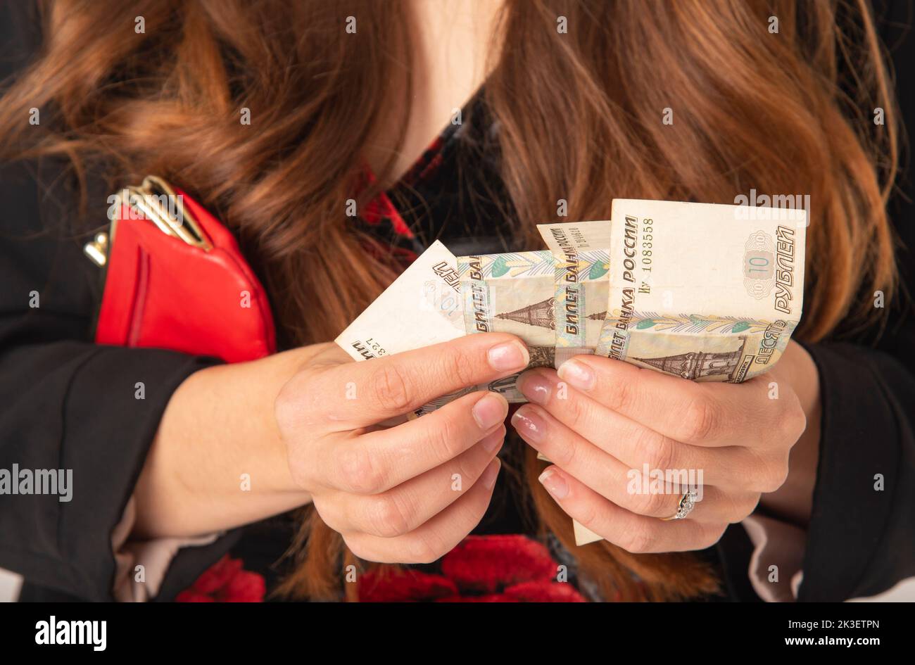 England UK. 2022. Woman with red purse counting Russian roubles Stock Photo