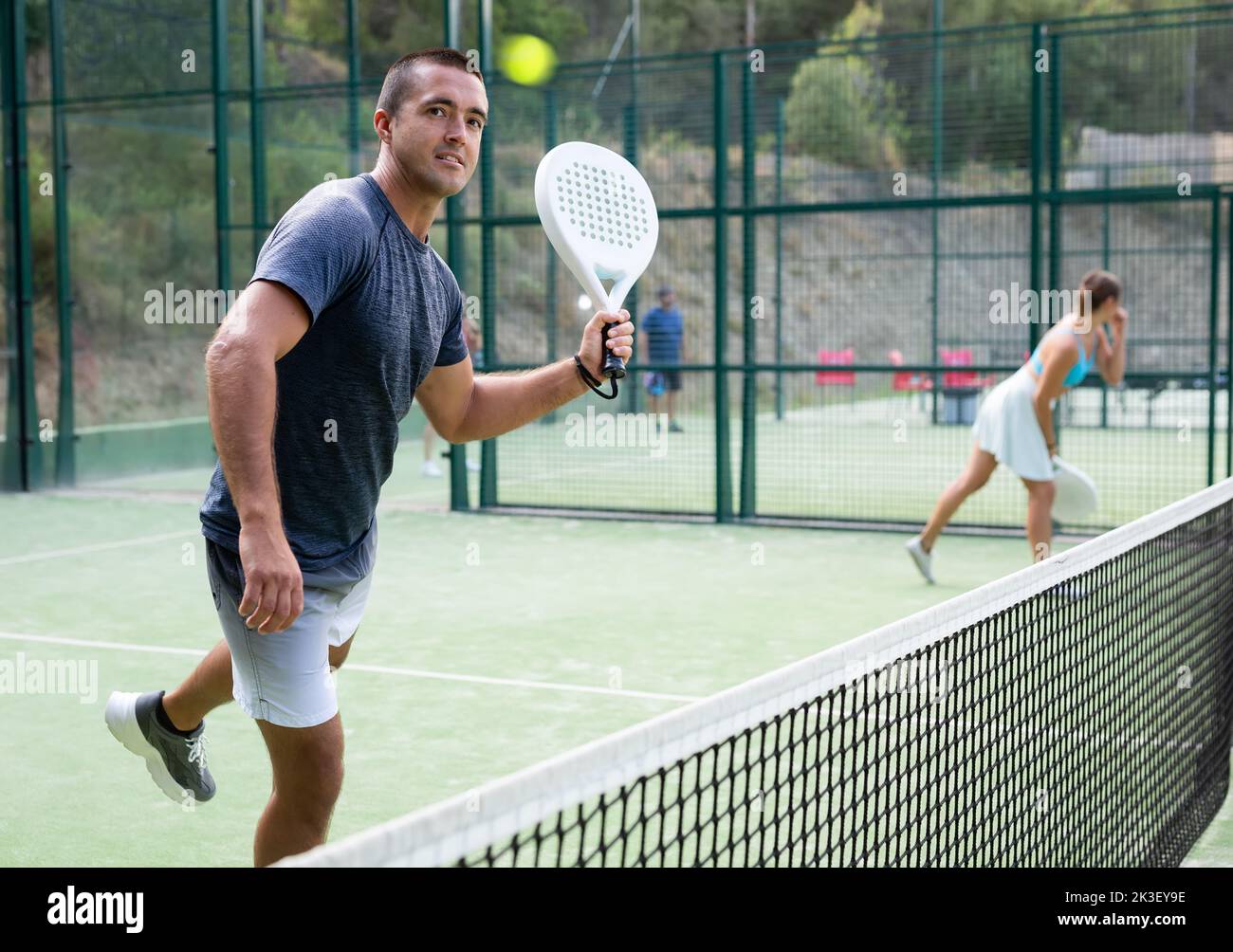Paddle tennis player preparing to perform left-handed forehand on ...