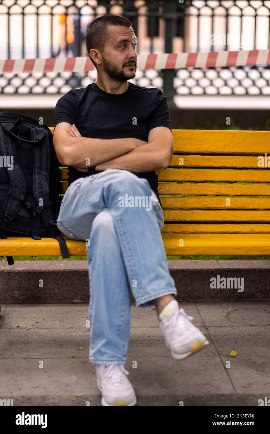 Caucasian man sits on a bench Stock Photo