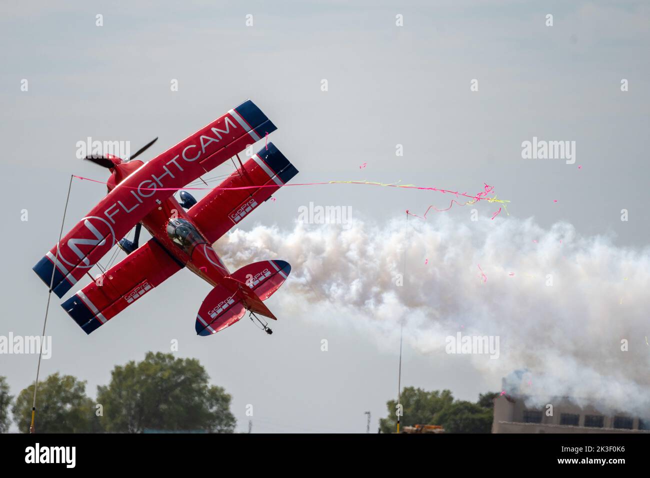 Brian Correll cuts a ribbon using his bi-plane during the 2022 Frontiers in Flight Air Show at McConnell Air Force Base, September 23, 2022 in Wichita, Kansas. Stock Photo