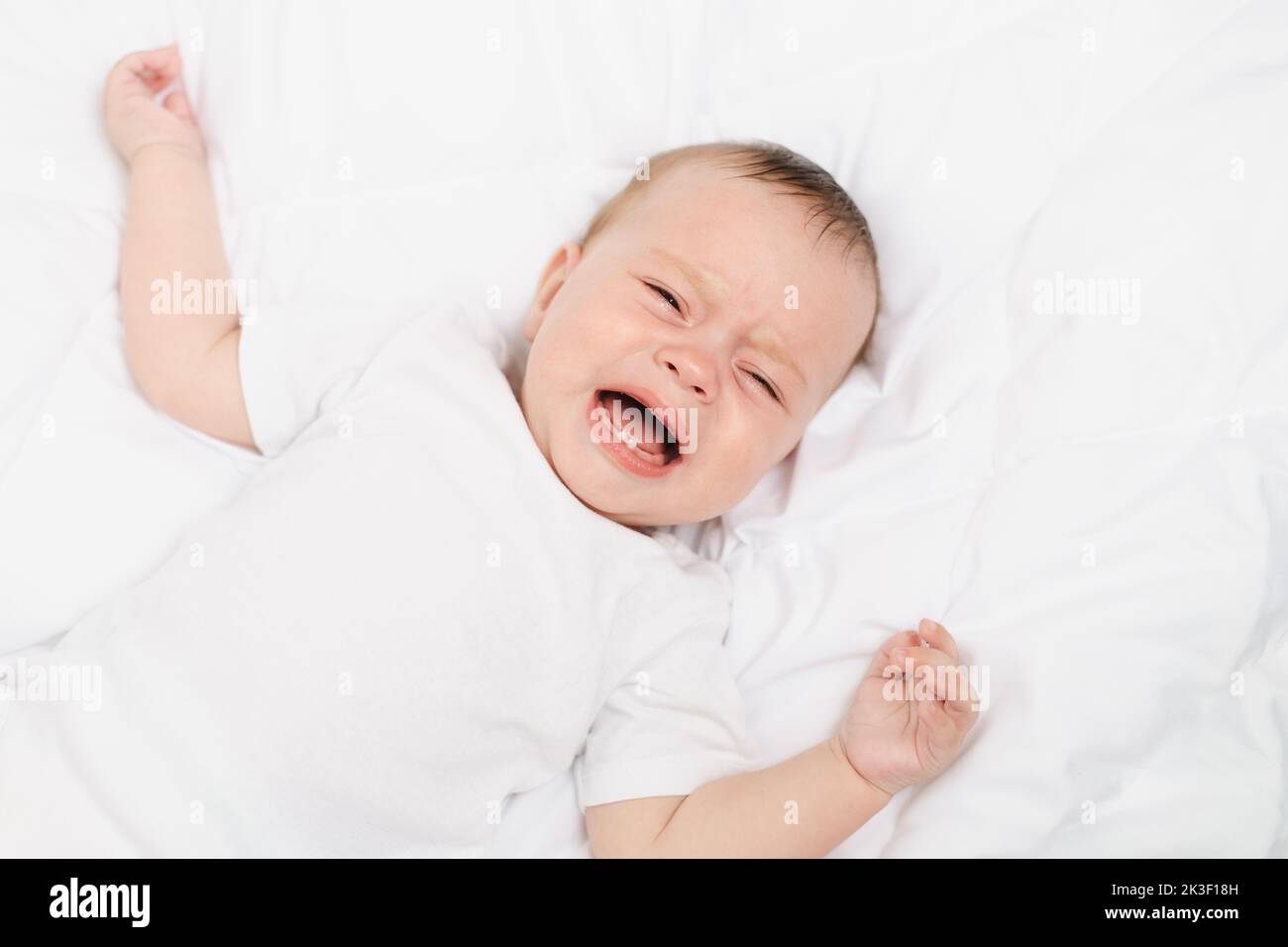 The baby is crying in his crib . The baby 's teeth are teething . Colic