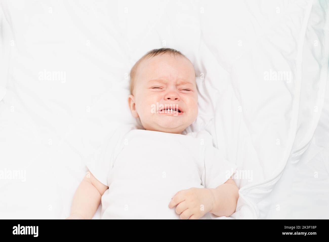The baby is crying in his crib . The baby 's teeth are teething . Colic