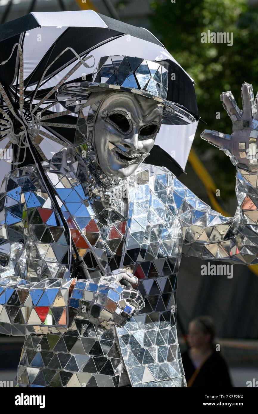 Person dressed up in a shiny mirror suit waving his hand, at the Beakerhead Festival in Calgary Alberta Canada Stock Photo