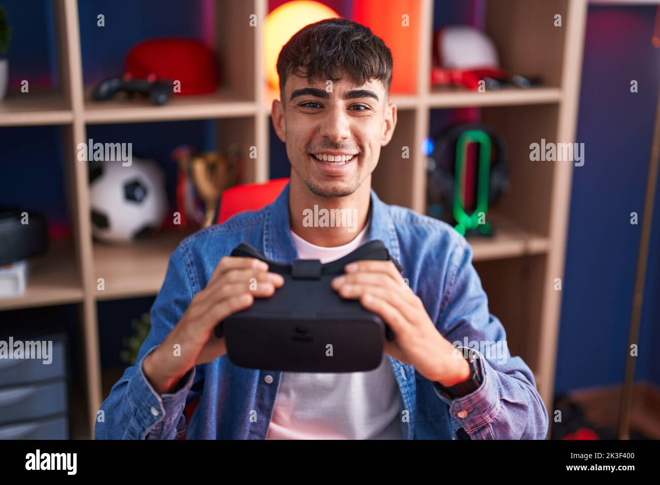 Young hispanic man wearing virtual reality glasses smiling with a happy ...