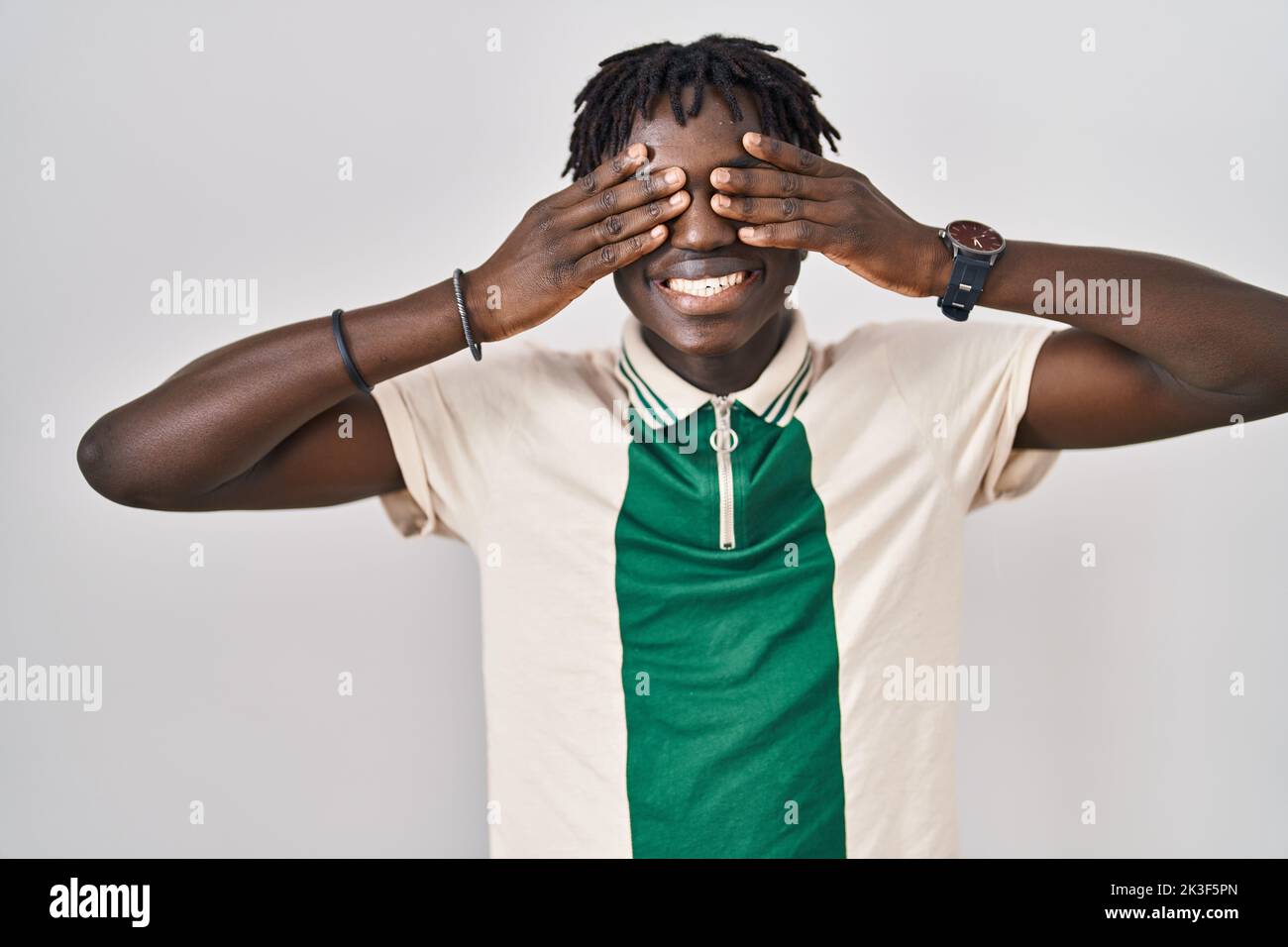African man with dreadlocks standing over isolated background covering ...