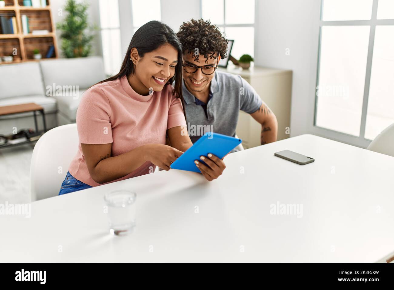 Young latin couple smiling happy using touchpad sitting on the sofa at ...