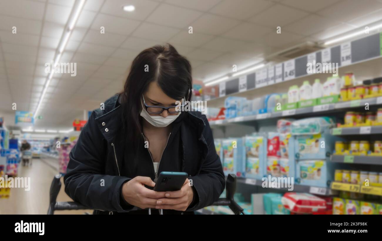 Young woman with mask shopping Stock Photo