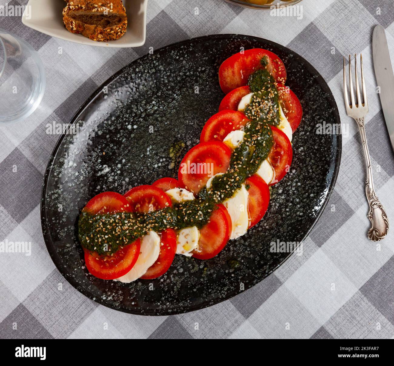Traditional dish of Italian cuisine caprese salad with fresh tomatoes and mozzarella cheese Stock Photo
