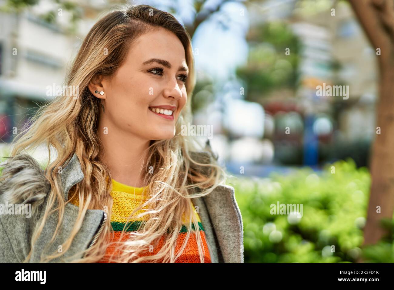 Young blonde woman smiling at the park Stock Photo - Alamy