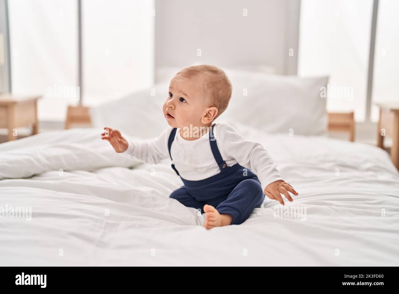 Adorable toddler sitting on bed at bedroom Stock Photo - Alamy
