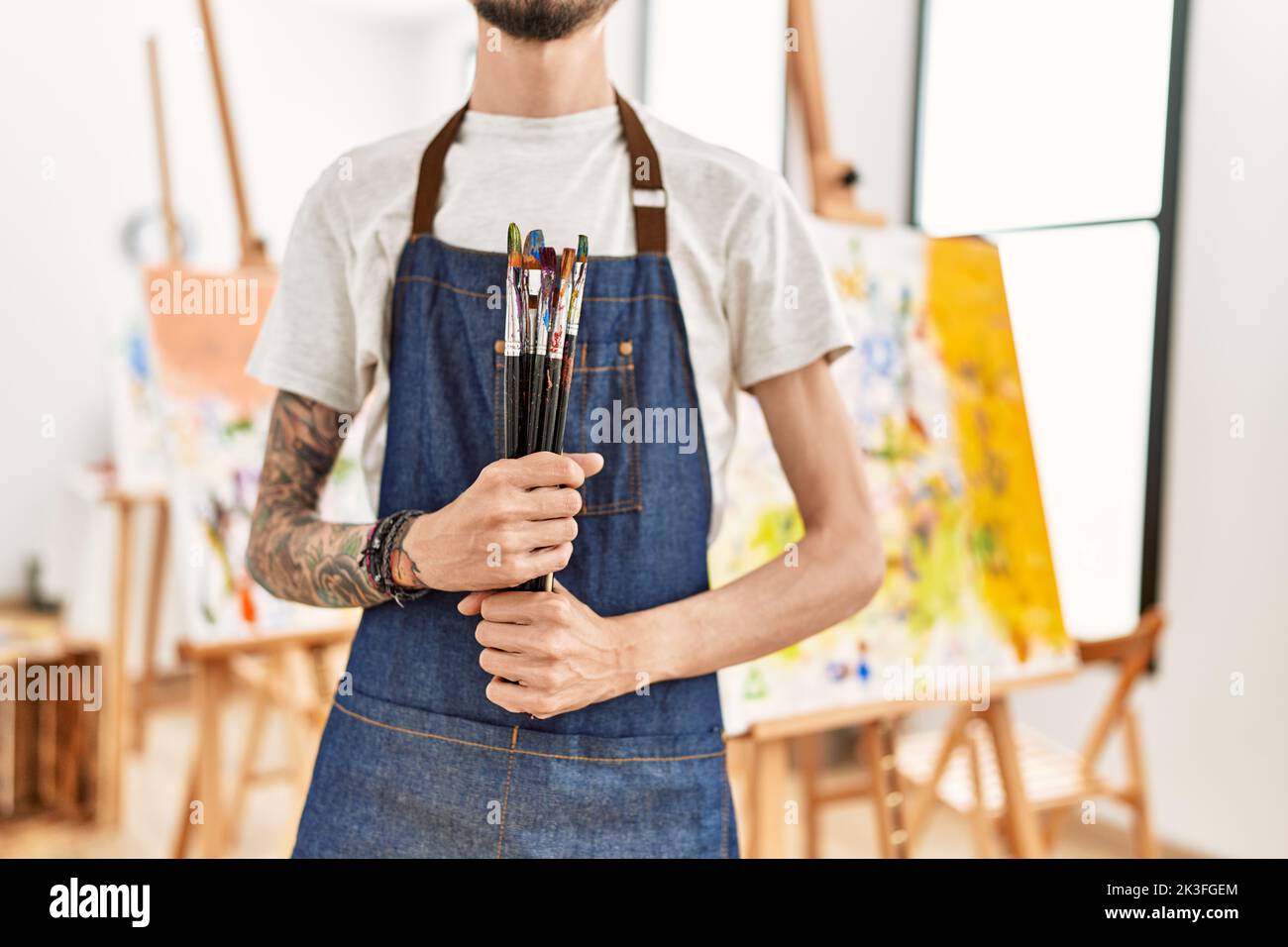 Man Using Art Tools Artist man holding paintbrushes at art studio Stock Photo - Alamy