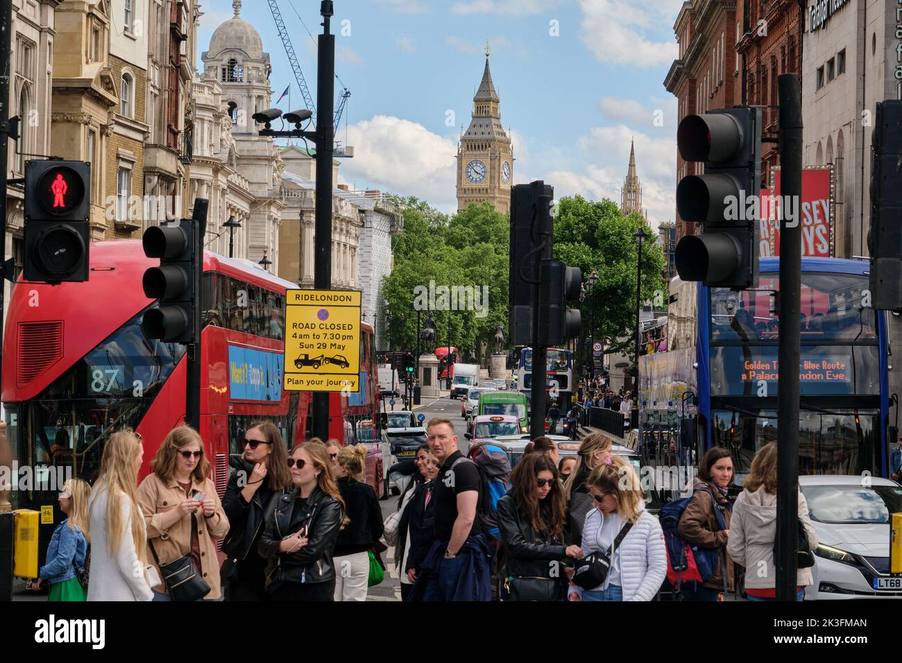 People waiting between the traffic lights near Trafalgar Square, London, with the Big ben and other Victorian buildings in the background. London life. Stock Photo