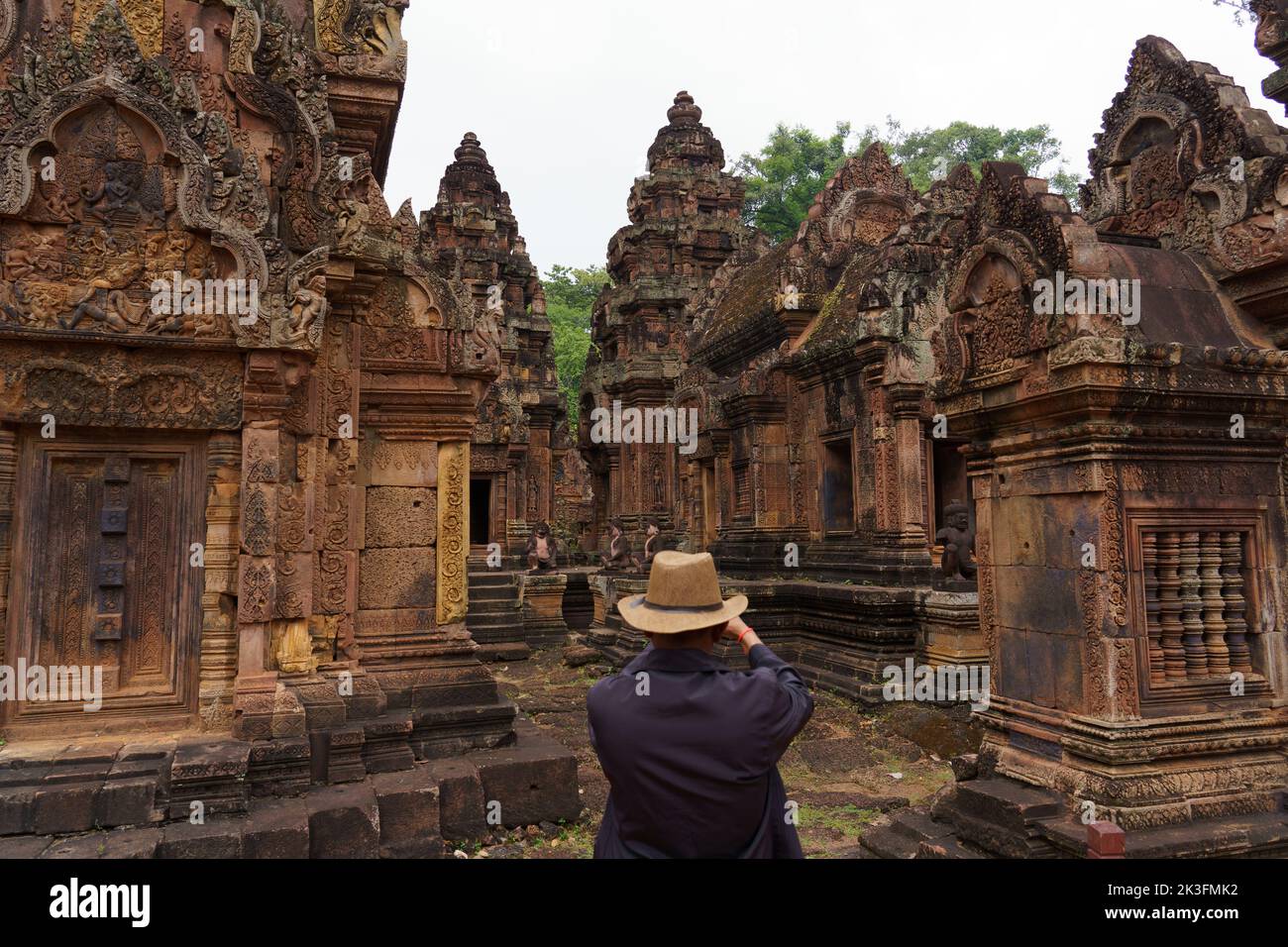 Cambodia. Siem Reap. The archaeological park of Angkor. A man photographs the temple of Banteay Srei 10th century Hindu temple dedicated to Shiva Stock Photo